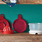 tupperware all in one mate rouge avec presse-agrumes, zesteur et séparateur d'oeufs sur fond vert